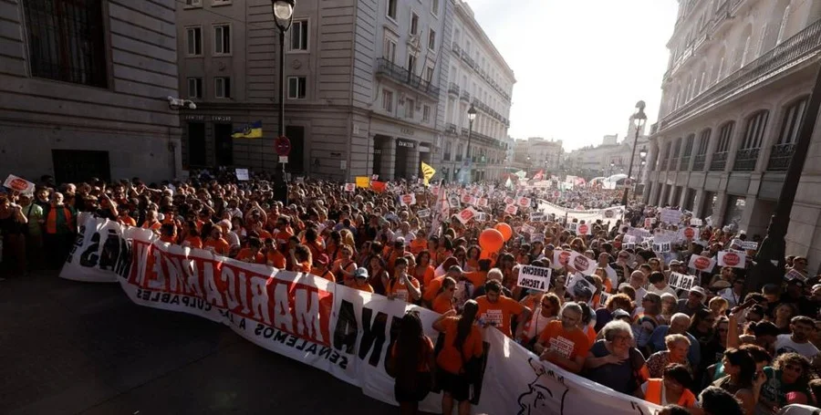 Protesters holding Maricarmen signs